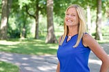 Kristin Ihle Helledy outside in front of a forest wearing a blue shirt