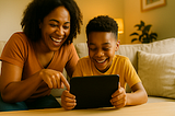Mother and her ADHD son watching something on a tablet and laughing.
