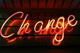 a neon sign that says change in cursive
