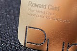 A close-up photo of a metal rewards card, designed to represent the alleged reward of white privilege.