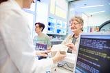 Pharmacist handing medication to customer