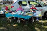 A picture of two people selling clothes at a market stall