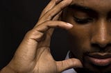 Man with hand on his head, eyes closed and thinking