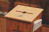 A Tithe/Offering box on a table in a church