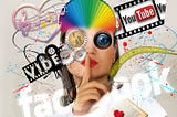 Woman making a shushing motion while surrounded by color, name brand text (Facebook, Vibe, YouTube). She has a digital eye that is a camera lens, gears around her and some money.