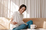 My Spring Morning Routine And How To Make Yours In No Time. the lazy gal medium.com women sitting down on couch reading sejal ghanate