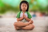 child in green and white shirt praying