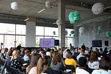 A shot of the audience at the opening session of the Disability Innovation Summit showing rows of people watching the stage.