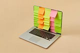 Laptop screen with organized lines of colored sitcky notes down the screen