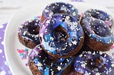 Galaxy donuts stacked on a plate. 