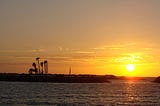 small island with palm trees silhouetted at sunset (melioration and serenity)