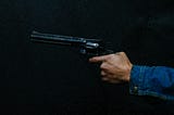 Image of a black hand holding a gun