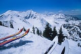 Skis at the edge of a steep ski slope.