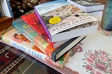 A stack of books on a glass coffee table