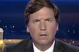 A photograph of Tucker Carlson facing the viewer and looking confused.