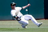 Oakland Athletics center fielder Sam Fuld makes a sliding catch on a pop fly from Seattle Mariners' Dustin Ackley during the first inning of a baseball game on Monday, Sept. 1, 2014, in Oakland, Calif. (AP Photo/Marcio Jose Sanchez)