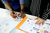 Colleagues viewing process metrics printouts.