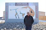 Ira standing in front of the Piikani First Nation’s Administration sign.