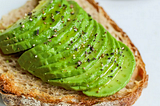 A photo of avocado slices on a piece of toast.