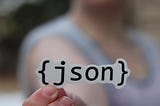 Un autocollant JSON dans la main d’une personne