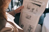 A woman is reading newspaper.