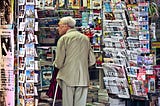 Image of an old man perusing postcards in Paris