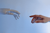 robotic hand reaching out to touch a human hand