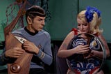 Spock strums his Vulcan lyre with one of the space hippies. Not exactly The Beatles, but…