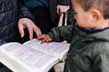 Adult engaging in explanation of book to child