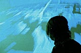 Silhouette of a woman against a blue and green background