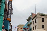 China Town San Francisco shows red chinese lanterns hanging between buildings over a closed street of street vendors in 2020.