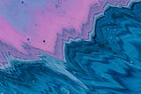 An illustration of a body of water. Deep blues pours out of one corner of the image; luminous pink-purple pours out of the opposite corner. Where the two meet and create a zig-zagging break runs across the middle of the image