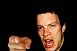 An angry man points and shouts