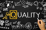 Quality written on a chalkboard with various drawings and symbols of what quality might mean