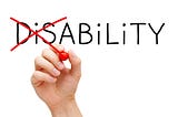 Hand turning the word Disability into Ability with red marker isolated on white.