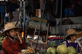 An old lady selling fruits at Amphawa’s floating market in Thailand