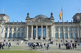 The stately Reichstag Building with the German flag flying in front, in Berlin, Germany