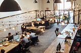 people sitting in front of computer monitors at a coworking space to fend off founder loneliness