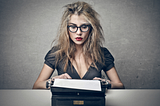 girl with messy hair typing on manual typewriter