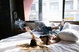 woman in bed smoking a joint