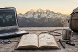 Alt-text: A rugged outdoor workspace set on a rustic wooden table with snow-capped mountains in the background. The gear laid out includes a heavy-duty laptop displaying a global network map, an open leather-bound journal with a mountain sketch and a “SHERPA INTELLIGENCE” stamp, a compass, keys on a carabiner, a tactical pen, a black USB drive, a steaming metal camp mug, a canvas backpack, and a pair of brown hiking boots.