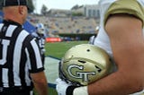 A GA Tech football player holds his helmet
