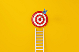 A target with an arrow hitting the bullseye with a ladder underneath it on a yellow background
