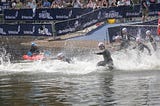 Swimmers running into the water at the start of a race.