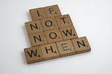 Scrabble tile letters form the phrase “If not now, when.”