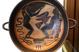 An ancient Greek black-figure kylix showing Prometheus bound to a pillar with an eagle pecking at his liver.