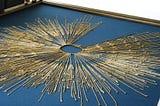 A gold circle of thread with long threads with knots on them connected to it, called a quipu