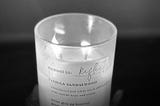 A lit candle with the words “moment to Reflect” written on it