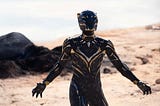 The new Black Panther in a new Black Panther costume stands on a beach in Black Panther: Wakanda Forever.