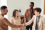 5 Ways to Boost Client Satisfaction image shows two women and two men in business attire. One woman and one man shake hands. All are smiling.